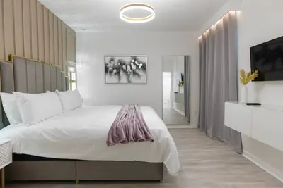 a bedroom with a large bed and a television at Brand New Home 8 BedroomsPoolSleeps 26 in Kissimmee