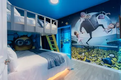 a bedroom with a bed with a disney mural at Brand New Home 8 BedroomsPoolSleeps 26 in Kissimmee