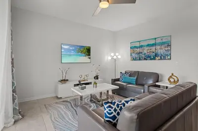 a living room with a couch and a table at Cozy & Stylish 2BR Condo Prime Storey Lake Spot in Kissimmee