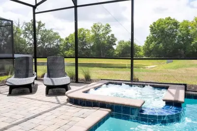 a patio with two chairs and a hot tub at Villa 6Q Disney Style c/ Piscina e Game Room in Kissimmee