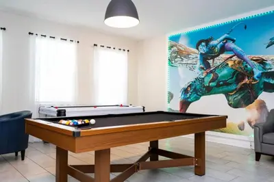 a living room with a pool table and a mural at Villa 6Q Disney Style c/ Piscina e Game Room in Kissimmee