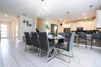 a dining room and kitchen with a table and chairs at Villa 6Q Disney Style c/ Piscina e Game Room in Kissimmee