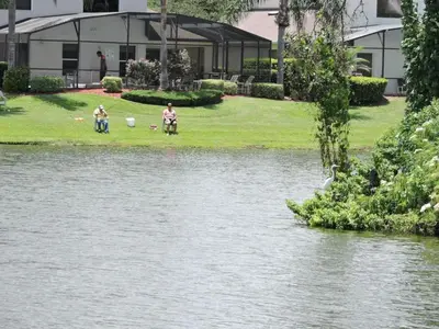 a group of people standing next to a body of water at 4701-Lake Berkley villa- Renovated 3 bed in Kissimmee