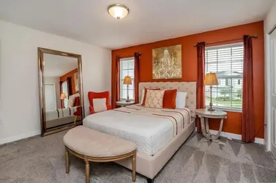 a bedroom with a large bed and a mirror at Casa 4Q com Piscina Aquecível — Storey Lake in Kissimmee