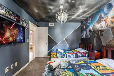 two beds in a room with marvel posters on the wall at Disney-Area Kissimmee 3BR | Community Pool in Kissimmee