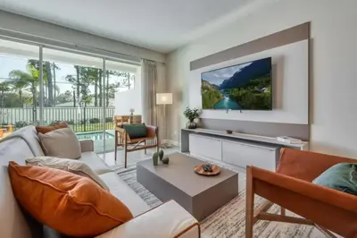 a living room with a couch and a tv at Casa 5Q com Piscina Privativa no Formosa in Orlando