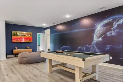 a living room with a pool table and a wall at Grand 15-Bedroom Villa -Magical Themes Pool & Game Loft Lakeview in Kissimmee