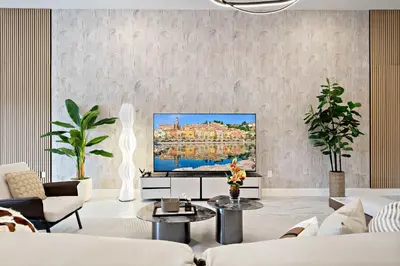 a living room with a flat screen tv on a wall at Grand 15-Bedroom Villa -Magical Themes Pool & Game Loft Lakeview in Kissimmee