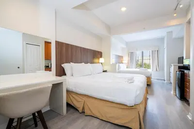a hotel room with a large bed and a desk at Near Universal Parks Cozy Apartament at The Point in Orlando