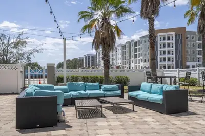 a seating area with blue couches and palm trees at Near Universal Parks Cozy Apartament at The Point in Orlando