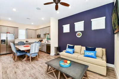a living room with a couch and a table at Palm Tree Paradise Cottage Near Disney With Margaritaville Resort & Island H20 Waterpark Access - 3087Pi in Orlando