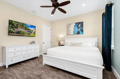 a bedroom with a white bed and a ceiling fan at Waterfront Cottage With Balcony And Private Pool Near Disney And Margaritaville Resort & Island H20 Waterpark Access - 3008Ph in Orlando