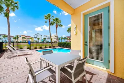 a patio with a table and chairs next to a pool at Waterfront Cottage With Balcony And Private Pool Near Disney And Margaritaville Resort & Island H20 Waterpark Access - 3008Ph in Orlando
