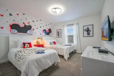 a bedroom with two beds and a wall with bat decorations at 2416 Luxo & Magia: Casa com Piscina no Storey Lake! in Kissimmee