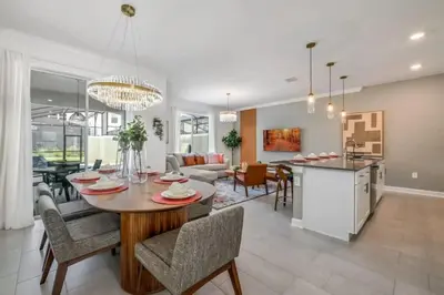 a kitchen and living room with a table and chairs at 2416 Luxo & Magia: Casa com Piscina no Storey Lake! in Kissimmee