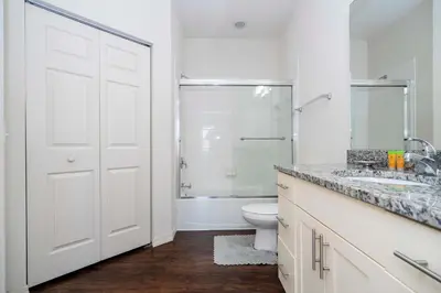 a white bathroom with a toilet and a shower at Spacious 4Bd Disney Dream with Resort Access at Lucaya 3210 in Kissimmee