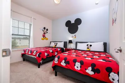two beds in a bedroom with mickey mouse comforter at Spacious 4Bd Disney Dream with Resort Access at Lucaya 3210 in Kissimmee