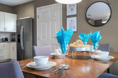a dining room table with blue napkins and a mirror at Spacious 4Bd Disney Dream with Resort Access at Lucaya 3210 in Kissimmee