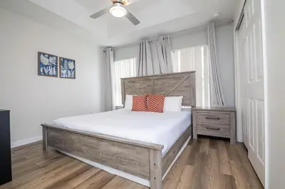 a bedroom with a bed with white sheets and a ceiling fan at Stunning 3 bedroom 3 bath townhome 370 in Kissimmee