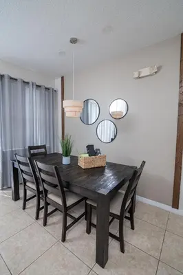 a dining room with a black table and chairs at Stunning 3 bedroom 3 bath townhome 370 in Kissimmee