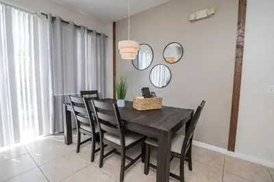 a dining room with a table and chairs and mirrors at Stunning 3 bedroom 3 bath townhome 370 in Kissimmee