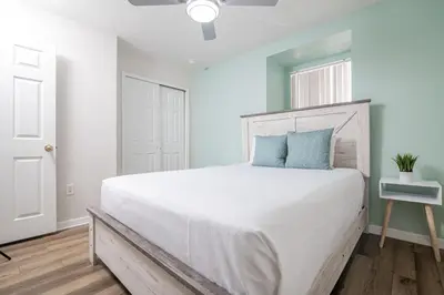 a bedroom with a large white bed with blue pillows at Stunning 3 bedroom 3 bath townhome 370 in Kissimmee