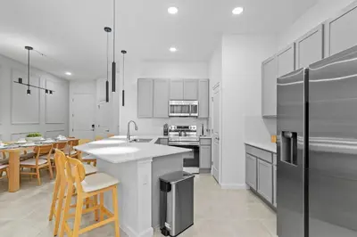 a kitchen with white cabinets and a stainless steel refrigerator at Luxury Paradise in Orlando Best Location in Orlando