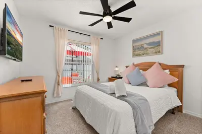 a bedroom with a bed and a ceiling fan at Family favorite Disney pool home in Kissimmee