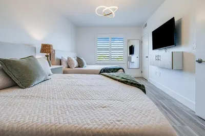 a bedroom with a large bed with a tv on the wall at Condo close to Epic Universe and Universal Studios in Orlando
