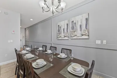 a dining room with a long table and chairs at 8893 Candy Palm Road in Kissimmee