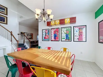 a dining room with a wooden table and colorful chairs at Free Water Park-Close to Disney-3 King-POOL-SPA in Orlando