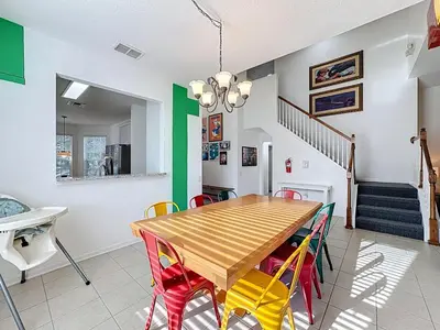 a dining room with a wooden table and colorful chairs at Free Water Park-Close to Disney-3 King-POOL-SPA in Orlando