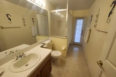 a bathroom with a sink and a toilet and a mirror at Lake View Pool Home near Disney and Shoppings in Kissimmee