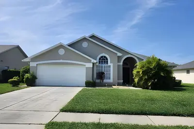 a house with a driveway and a garage at Lake View Pool Home near Disney and Shoppings in Kissimmee