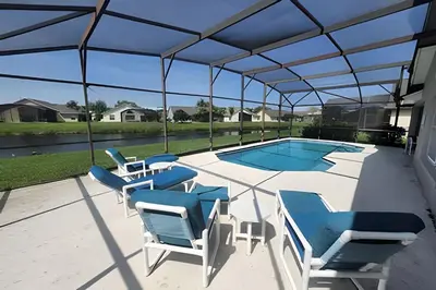 a patio with chairs and a swimming pool at Lake View Pool Home near Disney and Shoppings in Kissimmee