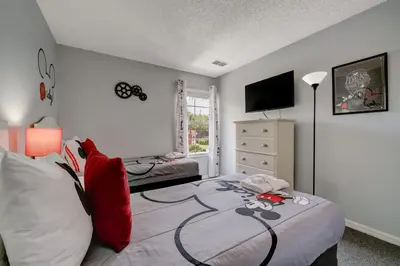 a bedroom with a bed with a controller on it at Family Retreat Near Disney in Emerald Island in Kissimmee