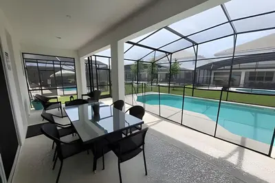 a dining room with a table and chairs and a pool at Fantastic Large Pool,Sonoma Resort in Kissimmee