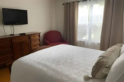 a bedroom with a bed and a chair and a television at Emerald Island Resort : Pool & Games Room in Kissimmee