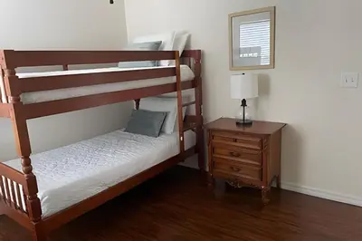 a bedroom with two bunk beds and a night stand at Emerald Island Resort : Pool & Games Room in Kissimmee