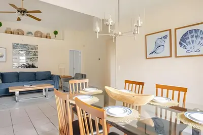 a dining room and living room with a table and chairs at 10 Minutes to Disney Pool Home *Renovated* in Kissimmee
