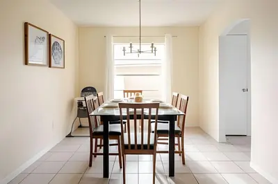 a dining room with a black table and chairs at 10 Minutes to Disney Pool Home *Renovated* in Kissimmee