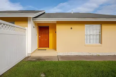 a yellow house with a red door at 10 Minutes to Disney Pool Home *Renovated* in Kissimmee