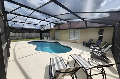 a patio with a swimming pool with a retractable roof at Lakeside Pool Home, Games close to Disney & Malls in Kissimmee