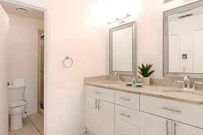 a white bathroom with two sinks and a toilet at Lakeside View Pool Home, close to Disney, Malls in Kissimmee