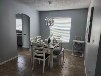a dining room with a table and chairs and a chandelier at Central Location Lakeview Pool Villa near Disney in Kissimmee
