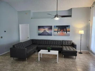 a living room with a couch and a table at Central Location Lakeview Pool Villa near Disney in Kissimmee