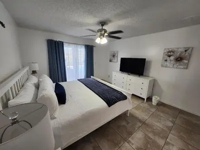 a bedroom with a bed and a flat screen tv at Central Location Lakeview Pool Villa near Disney in Kissimmee
