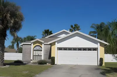 a house with a white garage at 10 Minutes to Disney! Pool Home Large Lot in Kissimmee
