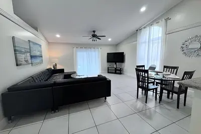 a living room with a bed and a table and chairs at 10 Minutes to Disney! Pool Hom, Large Backyard in Kissimmee