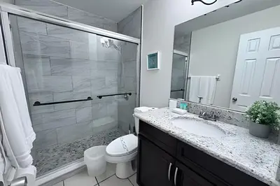 a bathroom with a shower and a toilet and a sink at 10 Minutes to Disney! Pool Hom, Large Backyard in Kissimmee